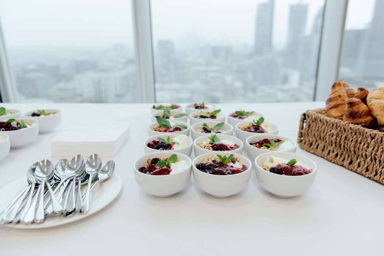 Delicious yogurt and croissants served buffet-style with city skyline view.